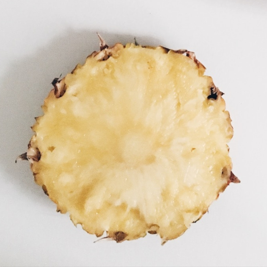 A pineapple slice with a mix of both yellow and whiter areas