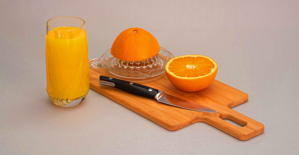 oranges and orange juice on a cutting board